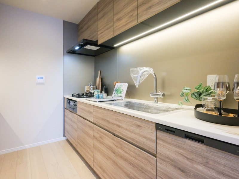 お部屋の色合いに調和した田中工藝製のシステムキッチンです。ガラストップを採用した美しく、お手入れのしやすいキッチンです。