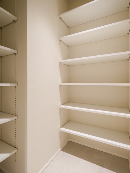 玄関からアクセスすることができる納戸には収納棚があります。可動式のため収納する物の高さに合わせて調整することができます。