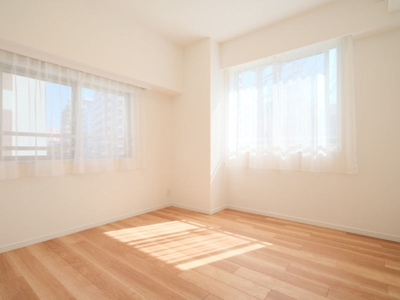 二面採光で、たっぷりの自然光が注がれる洋室1です。温もりを感じるフローリングやホワイトで統一された壁紙がやわらかい雰囲気を演出しています。