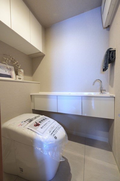 タンクレストイレを採用しすっきりとした印象にまとめたレストルームです。収納と手洗いスペースを備え、小物類等も収納しやすく、快適に使用できます。