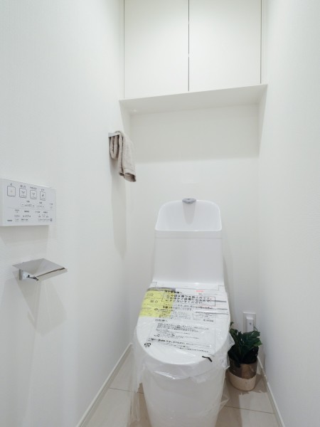 温水洗浄便座付きトイレへ新規交換済みです。上部には吊戸棚が設けられ、トイレットペーパーや清掃用具の収納に活用できます。