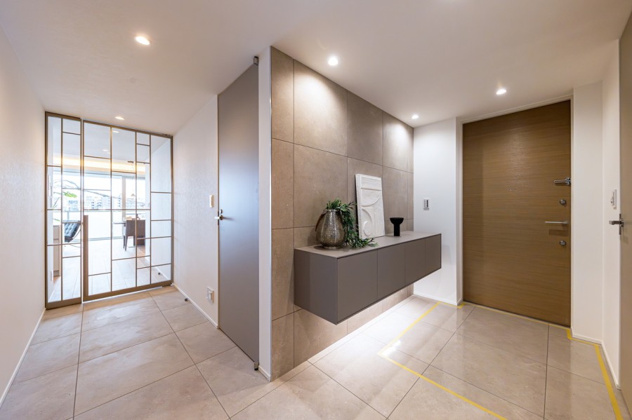 リビングから光が差し込み、廊下と一体感を感じられる広々とした洗練された玄関です。シューズインクローゼットが備わっており、豊富な棚付きでシューズはもちろん、アウトドアグッズや雨具なども収納可能です。