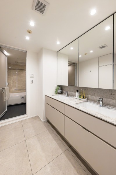 洗面化粧台は、キッチンと同じく田中工藝製で上品さが宿ります。大きな鏡がラグジュアリーな印象を与え、ワンランク上のライフスタイルをつくる洗面室となっています。