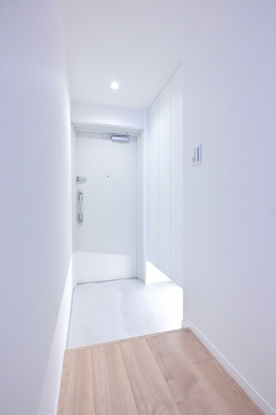 住まいの顔となる玄関は明るいホワイトカラーで仕上げました。フットライトが足元を照らし、天井まで高さのあるシューズボックスにはたっぷりと収納可能です。