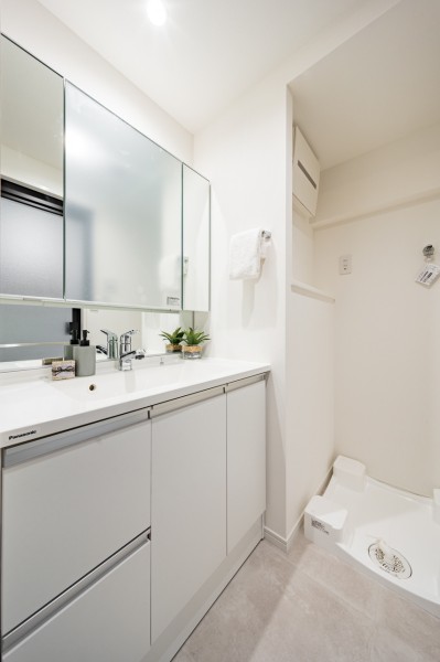 空間に美しく溶け込む洗面化粧台は、大きな三面鏡で身だしなみも整えやすく、収納豊富で実用的な洗面空間です。