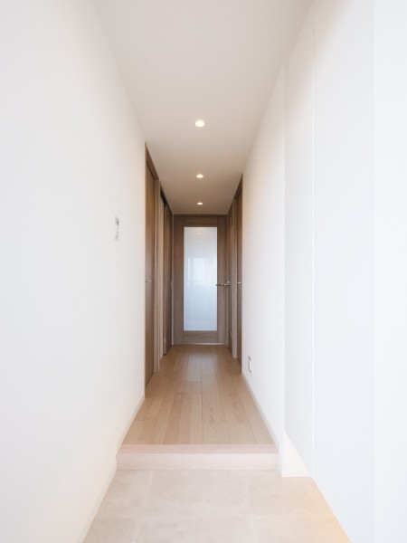 白を基調とした清潔感のある玄関です。フットライトが足元を温かく照らし、明るい空間が出迎えてくれます。