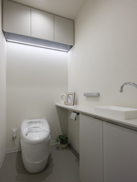 シックでまとめられたレストルームは安らぎのスペースです。カウンターや吊戸棚、手洗い場など有効的に使えそうな設備を設置。毎日使う場所だからこそ、清潔感と使いやすさを考慮した空間です。