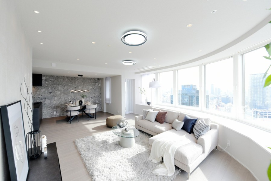 Rを描いた印象的なリビングです。一面窓になっていますので、梅田の景色や夜景をパノラマ眺望で堪能出来ます。南向きですので明るく暖かい光が差し込むくつろぎの空間です。