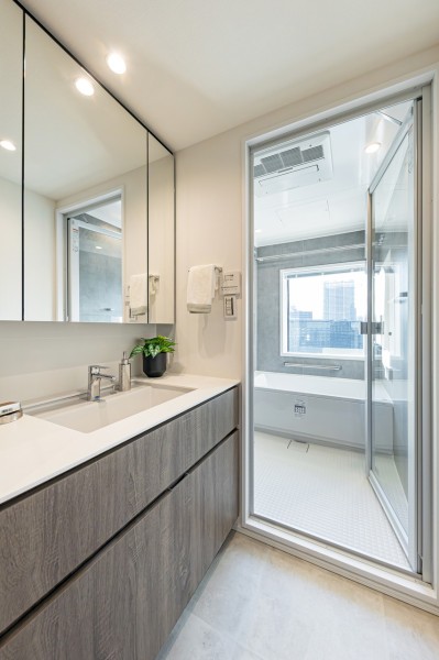 入浴後の豊かな時間を演出し、心からくつろげるプライベートスペースの洗面空間です。大きな三面鏡で身だしなみも整えやすく、収納豊富で実用的な洗面化粧台です。