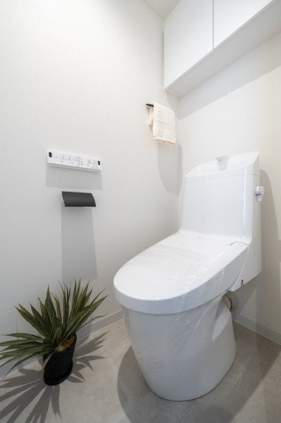 LIXIL製洗浄便座付トイレを新規設置しました。お掃除の手間を減らしてくれる機能が充実したトイレです。吊戸棚を設け、掃除用品やペーパー類のストックがすっきりと収納いただけます。