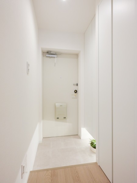 フットライトからのびる光が足元を優しく包み込む気品溢れる玄関です。白を基調とした清潔感のある玄関です。