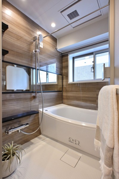 バスルームにも窓があります。光沢のある木目調パネルが高級感を漂わせるバスルームです。毎日のバスタイムを贅沢に、豊かにしてくれるバスルームです。