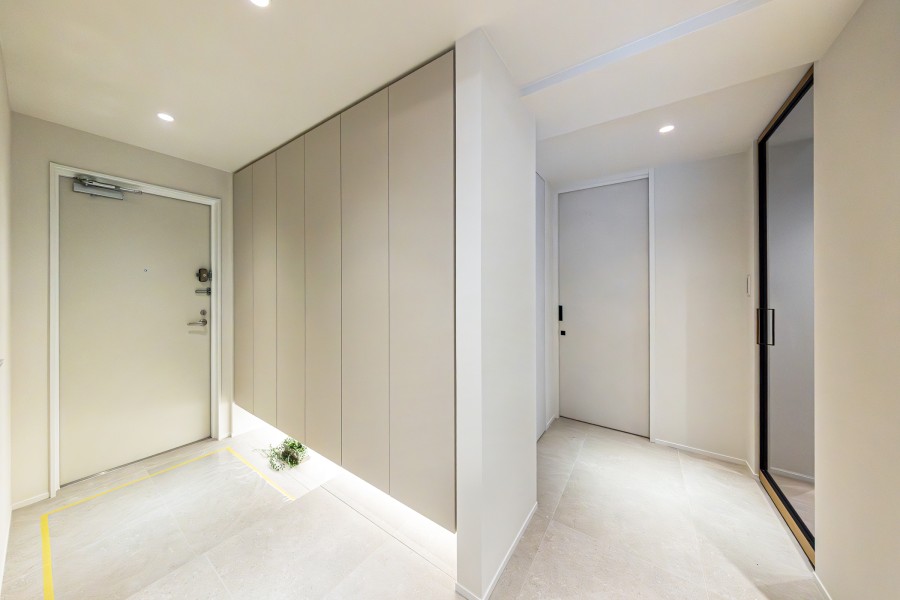 フットライトがやさしく足元を照らす玄関です。天井までの高さがある大きなシューズボックスにはたっぷりと収納いただけます。