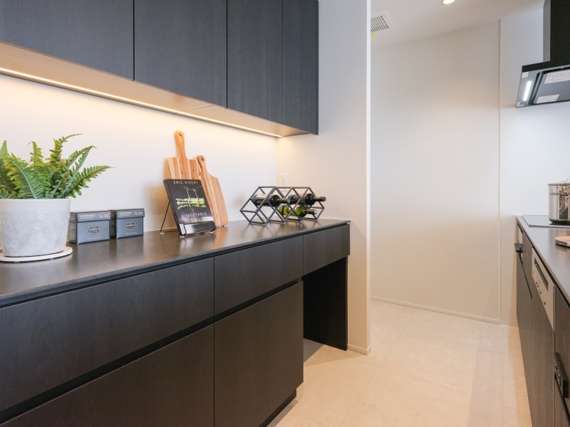 背面にはキッチンとお揃いでスタイリッシュなカップボードを備え付けました。間接照明がよりいっそう上質空間を創り出す気品溢れるキッチンです。