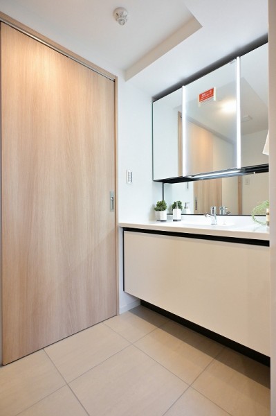 LIXIL製の洗面化粧台は白を基調としたデザインで、清潔感あふれる空間を演出します。シンプルでありながら機能性にも優れています。