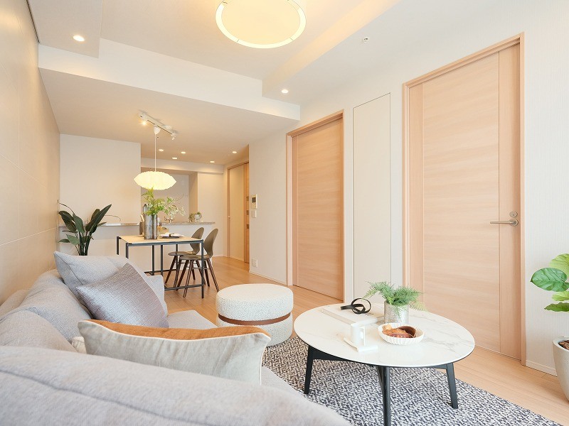 お部屋の建具はナチュラルなウッド面材のデザインです。リビングにも扉付き収納があり、日常でさっと取り出して使いたい細々としたアイテム等をしっかり収納いただけます。