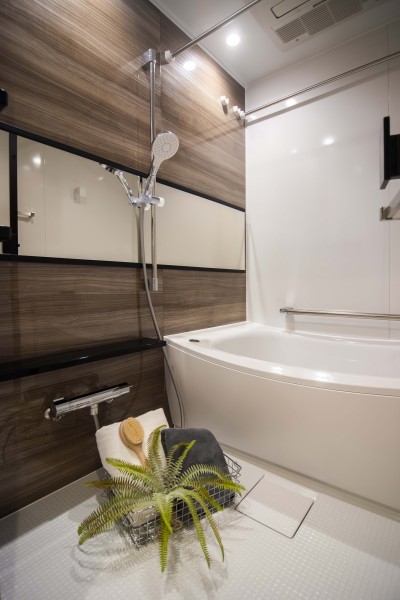 光沢のある木目調パネルが高級感を漂わせるバスルームです。