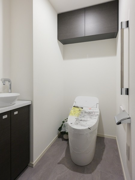 上品さが宿るレストルームには空間をすっきりと保つことが叶う上部吊戸棚収納、スマートなタンクレストイレが設置されています。手洗いカウンター付きでゲストの皆様も動線を気にすることなくお使いいただけます。