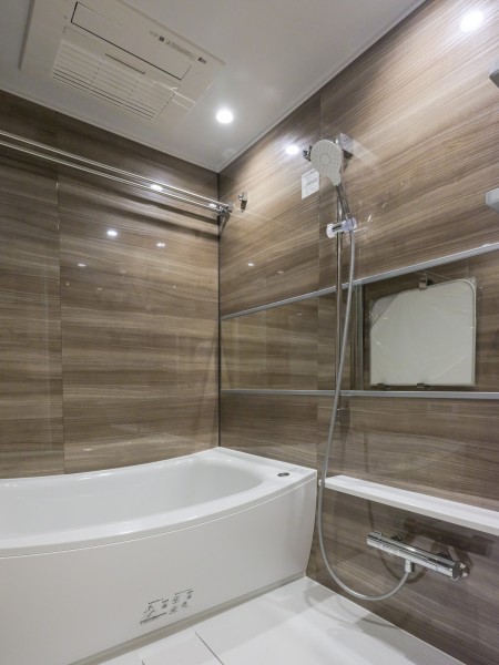 光沢感のあるパネルが高級感を漂わせる広々としたバスルームです。ゆったりとしたカーブが特長のバスタブで、一日の疲れをしっかりと癒すリラクゼーションタイムをお楽しみください。