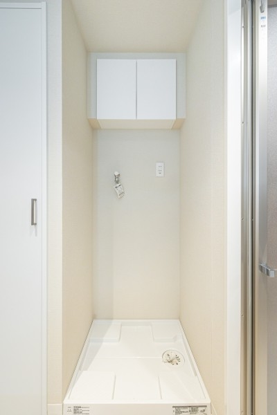 洗濯機置場には、洗剤などの収納に便利な吊り棚を備え付けました。こまごました物が多くなるスペースだからこそ、使いやすさを重視した工夫を詰め込みました。