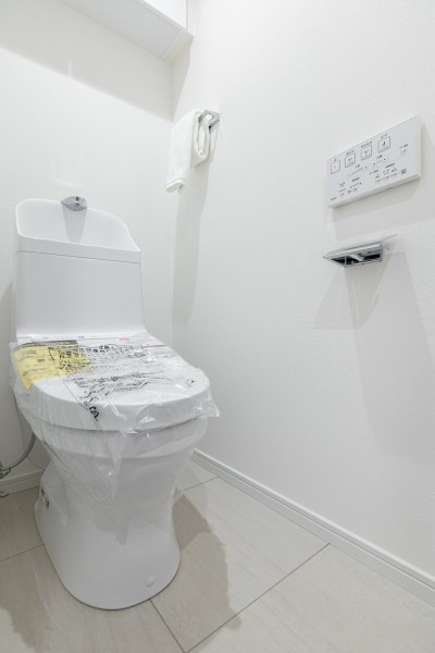 レストルーム収納は上部吊戸棚式にすることで、足元のスペースをすっきりとさせながらも、ペーパー類のストックをしっかりと保管できるように仕上げています。