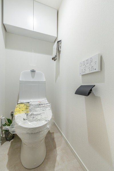 ホワイト基調のシンプルで安らぎが宿るレストルームです。トイレットペーパーなどの収納に便利な吊戸棚を備え付けました。