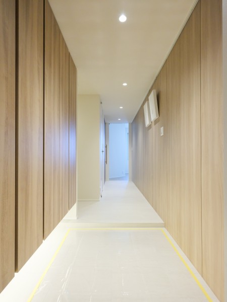 優しいウッドの色合いが映える、明るく格調高さが溢れる玄関です。人感センサー照明と天井までの高さのシューズボックスを備え付けました。居住者様や来訪者様を先に続く上質な居住空間へと優しく誘います。