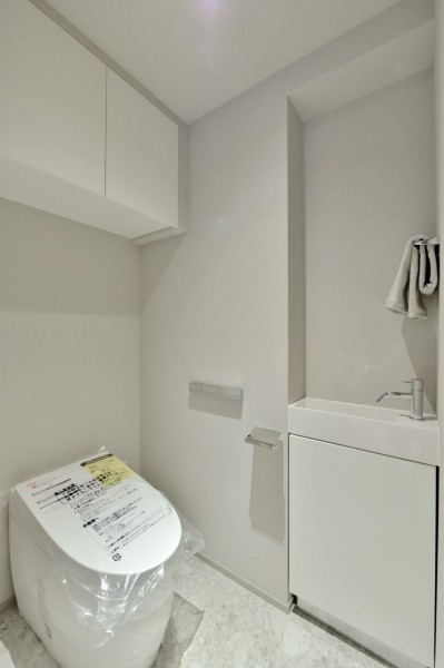 TOTO製タンクレストイレを採用しました。毎日使う場所なのでスタイリッシュでシンプル、清潔感のある空間に仕上げました。吊戸棚があり、小物類の収納に便利です。手洗いカウンターも設置済みです。