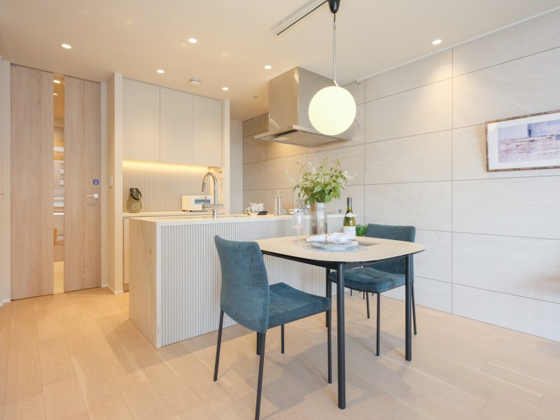 縦ラインを意識したバーチカルブラインドとキッチンのリブパネル、廊下にも光を届けるフルハイトドアが呼応し、一体感のある内装を施した住まいです。大切な日常を、より丁寧で心安らかに過ごせる居住空間です。