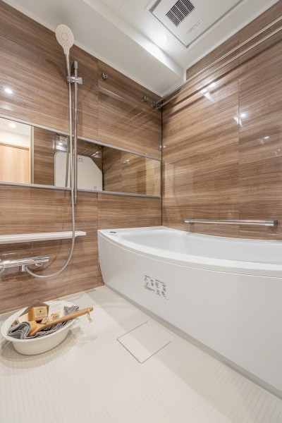 光沢のある木目調パネルが高級感を漂わせるバスルームです。1418サイズで、ゆったりと体を受け止めてくれる浴槽で癒しのバスタイムをお楽しみいただけます。