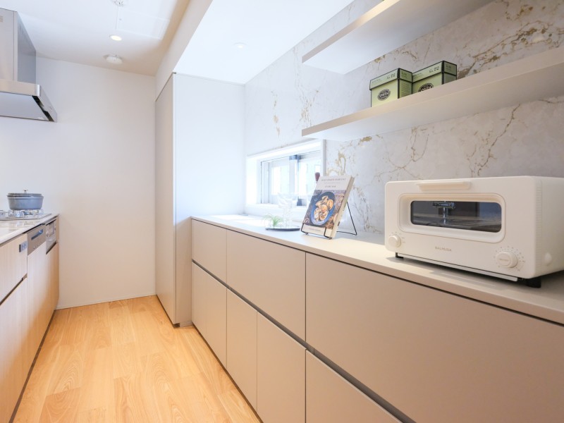 小窓から光を取り込んだキッチン背面には、流れ目の美しい石調デザインを取り入れるこだわりも。アクセントが入ったことでよりリュクスな印象に仕上げています。