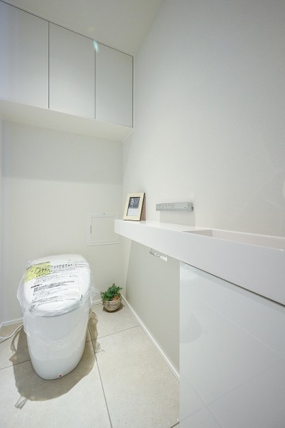 レストルームにはタンクレストイレと吊戸棚、手洗い場を設置いたしました手洗い場には、小物を設置することができるスペースがあり、お好みのレストルームにすることができます。柔らかい印象のホワイトカラーをクロスに使用し、落ち着いた空間となっております。