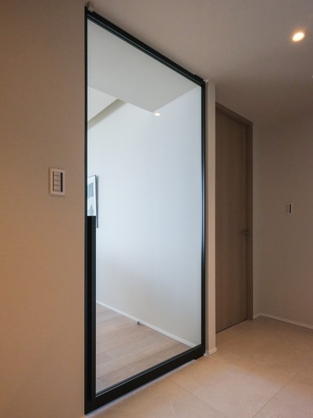 LDへ続く扉はガラス扉で、空間に美しく溶け込む高いデザイン性と開放感のある扉となっております。玄関廊下にもリビングからの穏やかな光を届けるシームレスな設計です。