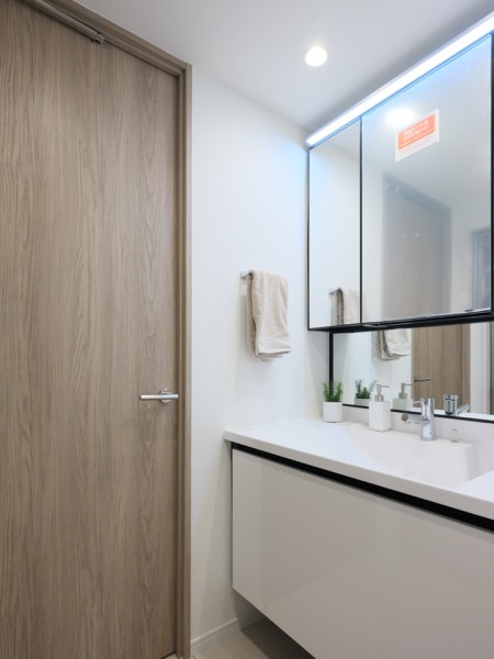 大きな三面鏡付きの洗面化粧台を新規設置しています。洗面ボウルは溝がなくお手入れのしやすいタイプを採用。使い心地も、お掃除のしやすさも兼ね備えた空間です。