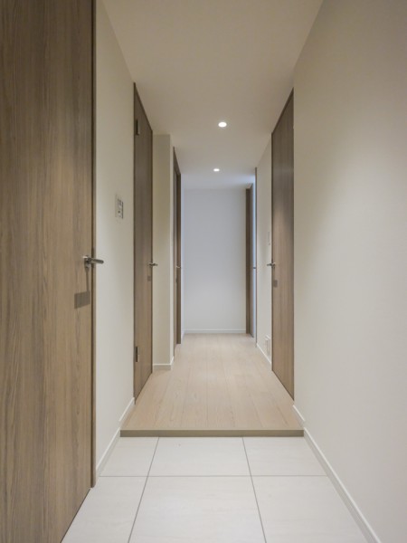 木のぬくもりと上品さを感じさせるホワイトを取り入れた玄関スペース。人感センサー照明を設置していますので、いつでも居住者様のお帰りを明るい空間が出迎えてくれます。