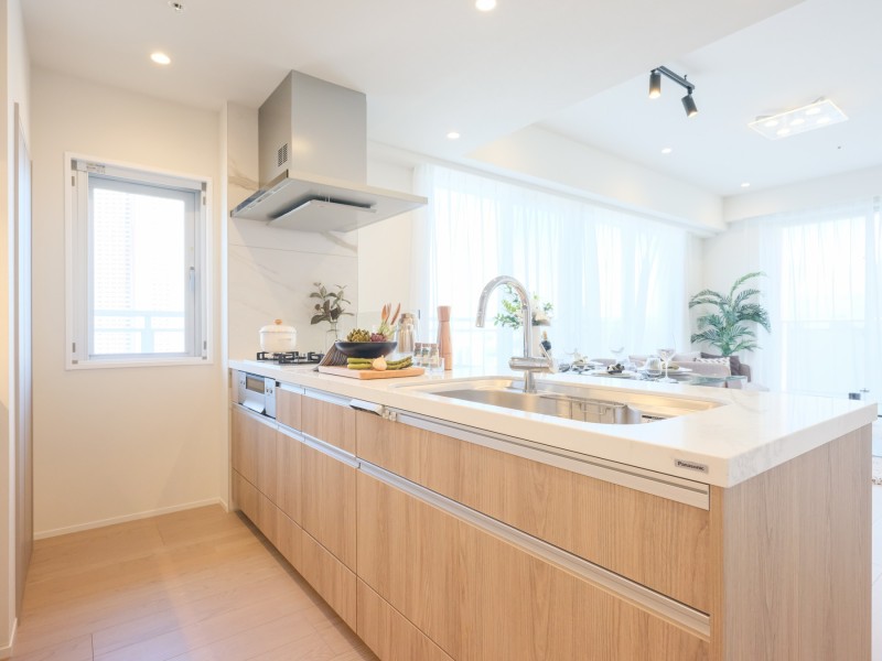 システムキッチンはゆったりと使用できる広さがあり、ご家族やゲストの方ともお料理を楽しむことができるスペースです。美しい木目の面材はインテリアの一部のようで、お部屋の雰囲気に溶け込みます。