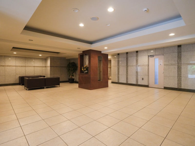 広々としたエントランスにはブラックカラーのソファと観葉植物やお花が生けられており、上質な空間となっております。お部屋に戻るまでに小休憩をしたり、ご近所の方とコミュニケーションをとることができるようになっております。