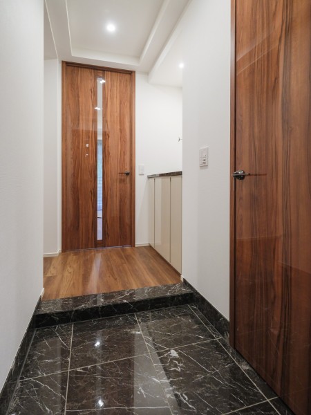 玄関は落ち着いた色彩で整えられ、格式高い空間を演出しております。シューズインクローゼットがあり、シューズやアウトドアグッズなどを収納できます。スペースをゆったりとお使いいただけます。