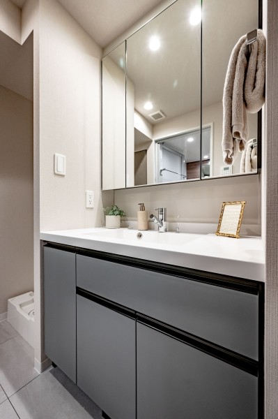 洗面化粧台は三面鏡裏と足元に収納棚があり、使用頻度の高い日用品や身支度グッズを収納することができます。洗濯機置き場が洗面室にあり、空間を広くお使いいただけます。