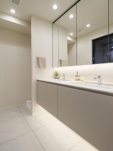 洗面室にはダブルボウルの洗面化粧台を設置し、ホテルのような空間へと仕上げています。朝の支度時間がご家族と重なったタイミングでも、ゆとりある空間での快適な準備が叶います。