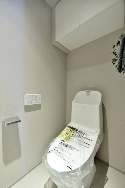 TOTO製ウォシュレット一体型のトイレ新規交換済みです。汚れのつきにくい素材、お手入れ簡単な機能を多数搭載しておりますので、いつも清潔な空間を保てます。吊戸棚を設置し、収納に便利です。