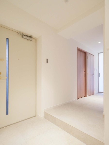 ベビーカーや大きな荷物もスムーズに。解放感のある玄関ホールは、ご家族の「ただいま」を優しく包む空間です。キッチン側には勝手口もあります。