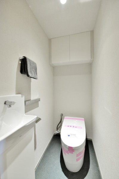 TOTO製ウォシュレット一体型のタンクレストイレを採用し、手洗いカウンターを設置しました。ゲストや家族が気兼ねなく、清潔に使用できます。吊戸棚を設置していますので、洗剤類や小物類もきれいに収納できます。