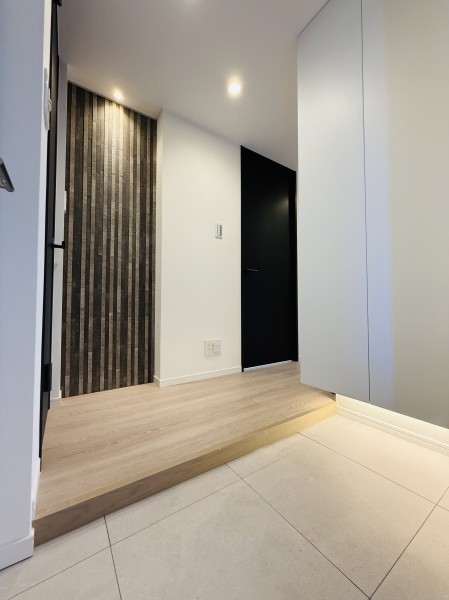 玄関には調湿や脱臭機能に優れたエコカラットタイルを施しました。ゆるやかな縦のラインのデザインが、穏やかで品のある雰囲気を生み出します。