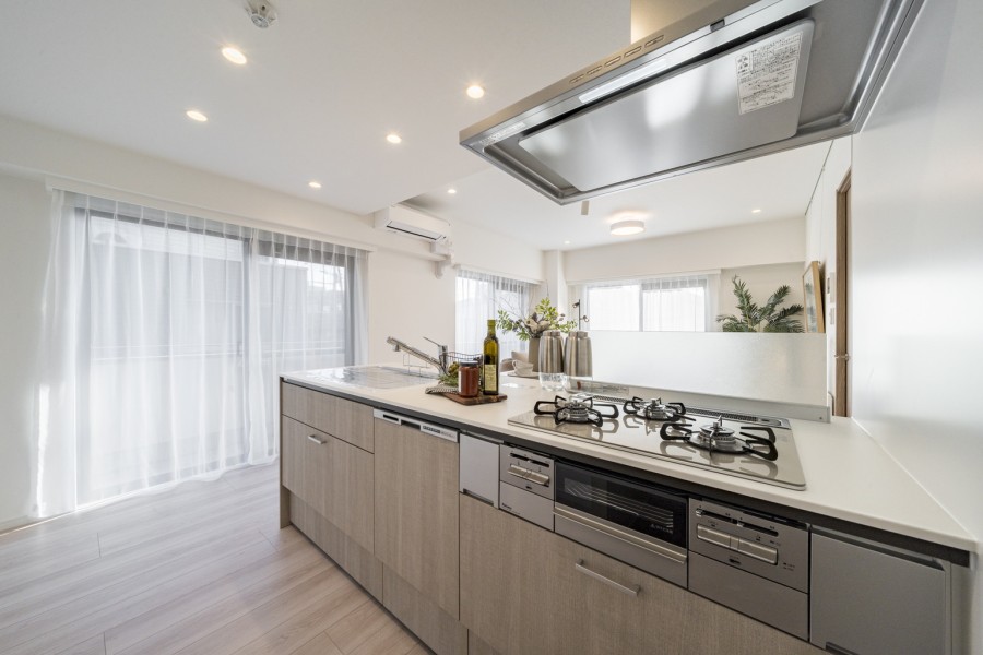 美しい木目の面材はインテリアの一部のようでお部屋の雰囲気に溶け込みます。コンロ前は仕切りがあるので、油ハネ等の心配もありません。