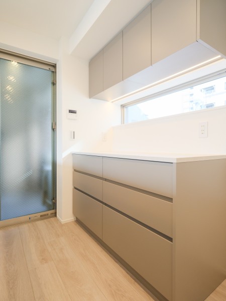 キッチンの背面にはお揃いのデザインのカップボードを設置しました。カウンター上には小窓があるので、開放感も感じる心地よいスペースです。