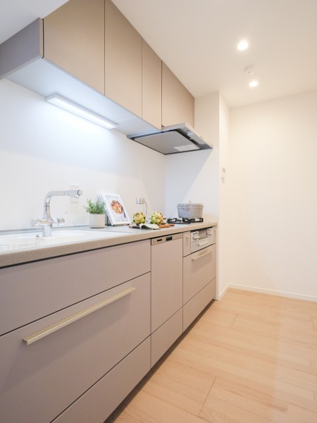 壁付けタイプのシステムキッチンには、家事時短に便利な食洗機も搭載しています。吊戸棚と足元に収納があり、食器や調味料など様々なものを収納することができます。