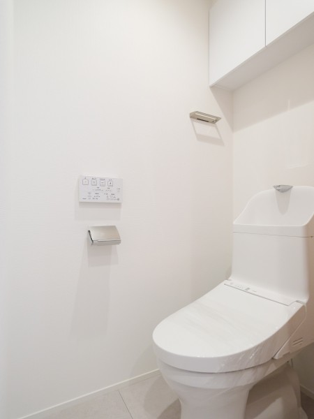 シンプルで安らぎが宿るレストルームです。吊戸棚にはトイレットペーパーや掃除用具を収納できるので便利です。