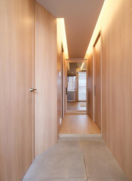 木目調の建具に囲まれた、温もりの感じられる廊下部分です。LDに続く扉は、シームレスで閉塞感を感じさせないガラス戸を採用しました。