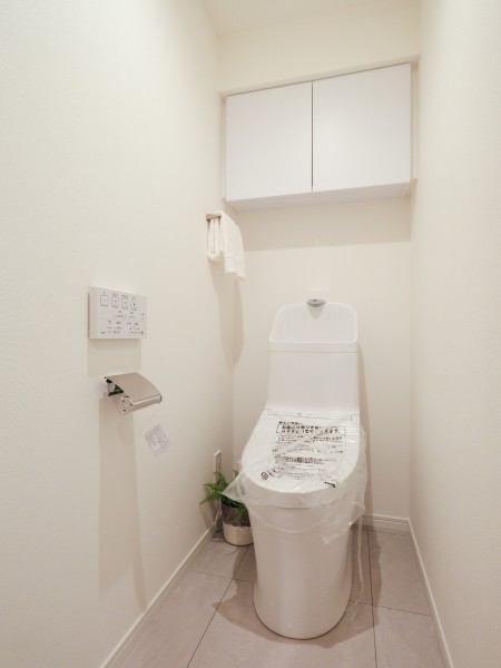 シンプルで安らぎが宿るレストルームです。TOTO製ウォシュレット一体型のトイレに新規交換済み。吊戸棚も設置したので、収納も便利です。